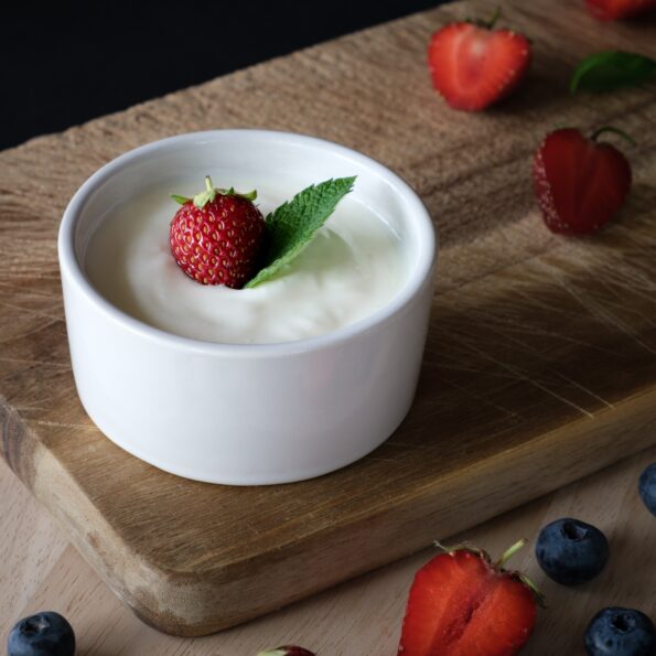 A bowl of creamy yogurt topped with fresh berries.